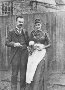 Herman und Lu Hollerith vor einem Holzzaun vor ihrem Heim in 3126 Dumbarton Street, Georgetown.